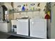 Functional laundry area equipped with washer, dryer, and shelving for storage at 631 San Pedro Dr, The Villages, FL 32159