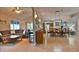 Open-concept living room with tile floors, a ceiling fan, access to the kitchen and dining area, and comfortable seating at 631 San Pedro Dr, The Villages, FL 32159
