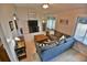 Comfortable living room featuring neutral colors, tile floors, and lots of natural light from the large window at 631 San Pedro Dr, The Villages, FL 32159