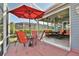 Relaxing screened patio with outdoor table, chairs, and red umbrella perfect for outdoor enjoyment at 631 San Pedro Dr, The Villages, FL 32159