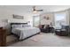 Spacious bedroom with a seating area, ceiling fan, and natural light from windows at 6401 Domenico Ct, Groveland, FL 34736