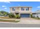 Charming two-story home with a well-manicured lawn, blue shutters, and a two-car garage at 6401 Domenico Ct, Groveland, FL 34736