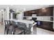 Modern kitchen featuring dark wood cabinets, a breakfast bar with patterned accents, and stainless steel appliances at 6401 Domenico Ct, Groveland, FL 34736