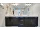 Modern bathroom showcases double sinks with black vanities and large mirror above them at 644 Orange Belt Loop, Winter Garden, FL 34787