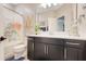 Well lit bathroom features a vanity with black cabinets and light colored world map shower curtain at 644 Orange Belt Loop, Winter Garden, FL 34787