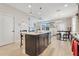 This modern kitchen features stainless steel appliances, a large island with seating, and overlooks the cozy dining area at 644 Orange Belt Loop, Winter Garden, FL 34787