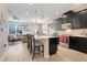 Modern kitchen features an island with seating, sleek black cabinetry, stainless steel appliances, and light wood floors at 644 Orange Belt Loop, Winter Garden, FL 34787