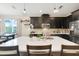 This modern kitchen boasts stainless steel appliances, dark cabinets, island with seating and backsplash at 644 Orange Belt Loop, Winter Garden, FL 34787