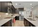 The beautifully designed kitchen has stainless steel appliances, dark cabinets, stylish backsplash, and light wood-look floors at 644 Orange Belt Loop, Winter Garden, FL 34787