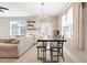 A dining space flows into a living room with a neutral sofa and decor, creating a welcoming atmosphere at 644 Orange Belt Loop, Winter Garden, FL 34787