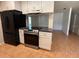 Open kitchen featuring stainless steel range and appliances, with tile flooring at 677 Warner St, Groveland, FL 34736