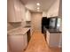 Galley kitchen features stainless steel appliances, granite countertops and tile flooring at 677 Warner St, Groveland, FL 34736