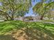 Beautiful single-story home with large, shady trees and a well-kept front lawn at 715 Megan Circle, The Villages, FL 32159
