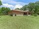 Large backyard with lush green grass and patio with a screened in sunroom at 7260 Se 124Th Ln, Belleview, FL 34420