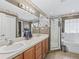 A full bathroom features a double sink vanity, stand up shower, tub and tile floors at 7260 Se 124Th Ln, Belleview, FL 34420