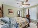 Cozy bedroom featuring a four-poster bed, ceiling fan, and lots of natural light at 7260 Se 124Th Ln, Belleview, FL 34420