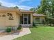 Close-up of home's entrance, featuring a screen door and manicured landscaping at 7260 Se 124Th Ln, Belleview, FL 34420