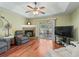 Cozy living room with fireplace, sliding glass doors to the lanai, and a ceiling fan at 7260 Se 124Th Ln, Belleview, FL 34420