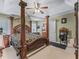 A sophisticated main bedroom features a four-poster bed, carpet, and an ensuite bathroom at 7260 Se 124Th Ln, Belleview, FL 34420