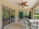 Sunroom with tile flooring, ceiling fan, large windows, and green curtains at 7260 Se 124Th Ln, Belleview, FL 34420
