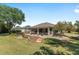 Exterior view of the property and the yard with a garden, landscaping and a screened in patio at 760 Hammond Pl, The Villages, FL 32162