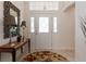 Bright foyer featuring stylish decor, including a decorative mirror, lamps, and a patterned rug at 760 Hammond Pl, The Villages, FL 32162
