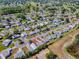 An aerial view of a residential neighborhood featuring tidy homes with well-maintained lawns and mature trees at 819 Hibiscus Dr, The Villages, FL 32159