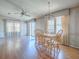 Open dining area with hardwood floors, chandelier, and bright natural light from three large windows at 819 Hibiscus Dr, The Villages, FL 32159