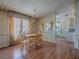 Cozy dining area featuring light wood floors, large window, and a view into the kitchen at 819 Hibiscus Dr, The Villages, FL 32159