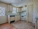 Functional kitchen with classic appliances, light wood cabinets, and adjacent exterior access at 819 Hibiscus Dr, The Villages, FL 32159