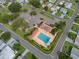 Aerial view of a community pool, surrounded by parking, landscaping, and neighborhood streets and homes at 819 Hibiscus Dr, The Villages, FL 32159