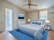 Cozy bedroom featuring a ceiling fan, TV, and an ensuite bathroom at 819 Hibiscus Dr, The Villages, FL 32159