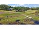 Enjoy this lakeside backyard with adirondack chairs, a dock, and ample green space at 848 Hawk Lndg, Fruitland Park, FL 34731