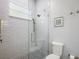 Bright bathroom featuring glass shower, subway tile, mosaic floors, and toilet at 848 Hawk Lndg, Fruitland Park, FL 34731