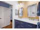 Beautiful bathroom with double sinks, wood wall and blue cabinets at 848 Hawk Lndg, Fruitland Park, FL 34731