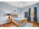 Blue bedroom featuring hardwood floors, window, and ceiling fan at 848 Hawk Lndg, Fruitland Park, FL 34731