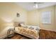 Bright bedroom features hardwood floors, ceiling fan, and large window at 848 Hawk Lndg, Fruitland Park, FL 34731