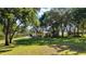 Charming yellow home with lush green lawn and mature trees, a peaceful suburban haven at 848 Hawk Lndg, Fruitland Park, FL 34731