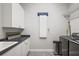 Efficient laundry room with white cabinets, ample counter space, and modern appliances for convenience at 848 Hawk Lndg, Fruitland Park, FL 34731