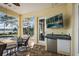 Outdoor patio with a flatscreen television, sink, and refrigerator, perfect for entertainment at 848 Hawk Lndg, Fruitland Park, FL 34731