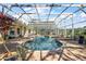 Enjoy this screened-in pool area complete with umbrellas, waterfall feature, and an outdoor grill at 848 Hawk Lndg, Fruitland Park, FL 34731