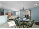 Open-concept design integrates the dining area and living room with a glass table, chairs, and sliding glass door at 9325 Se 172Nd Garden St, The Villages, FL 32162