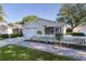 Charming single story home boasts lovely landscaping, a white picket fence, and a welcoming screened in porch at 9325 Se 172Nd Garden St, The Villages, FL 32162