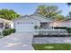 Charming single-story home with a white picket fence, well-maintained lawn, and a one car garage at 9325 Se 172Nd Garden St, The Villages, FL 32162