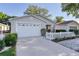 Charming single-story home featuring a white picket fence, manicured landscaping, and attached one car garage at 9325 Se 172Nd Garden St, The Villages, FL 32162