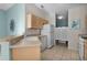 Well-lit kitchen featuring light wooden cabinets, modern appliances, and tile flooring, seamlessly connecting to other rooms at 9325 Se 172Nd Garden St, The Villages, FL 32162