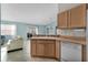Open kitchen with wood cabinets and views of the living room at 9325 Se 172Nd Garden St, The Villages, FL 32162