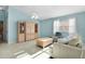 Open living room with light blue walls, tile flooring, wooden built in and comfortable neutral and blue furniture at 9325 Se 172Nd Garden St, The Villages, FL 32162