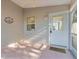 Enclosed porch featuring a ceiling fan, decorative wall art and a 'Happy Place' welcome mat at the front door at 9325 Se 172Nd Garden St, The Villages, FL 32162