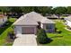 Attractive home with lush front lawn, mature tree shading, and inviting two-car garage at 9593 Se 124Th Loop, Summerfield, FL 34491